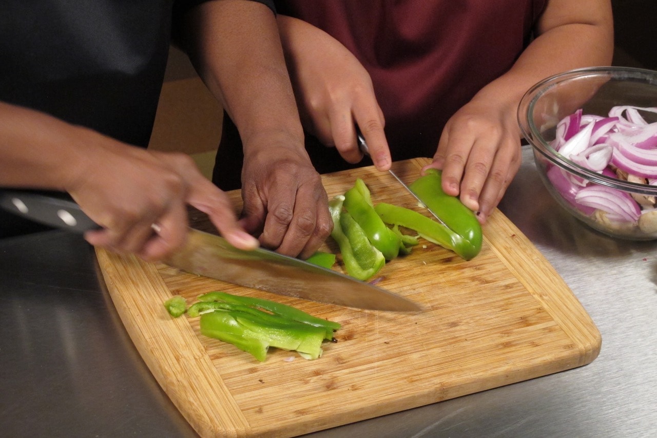 While tortillas are cooking, slice vegetables.